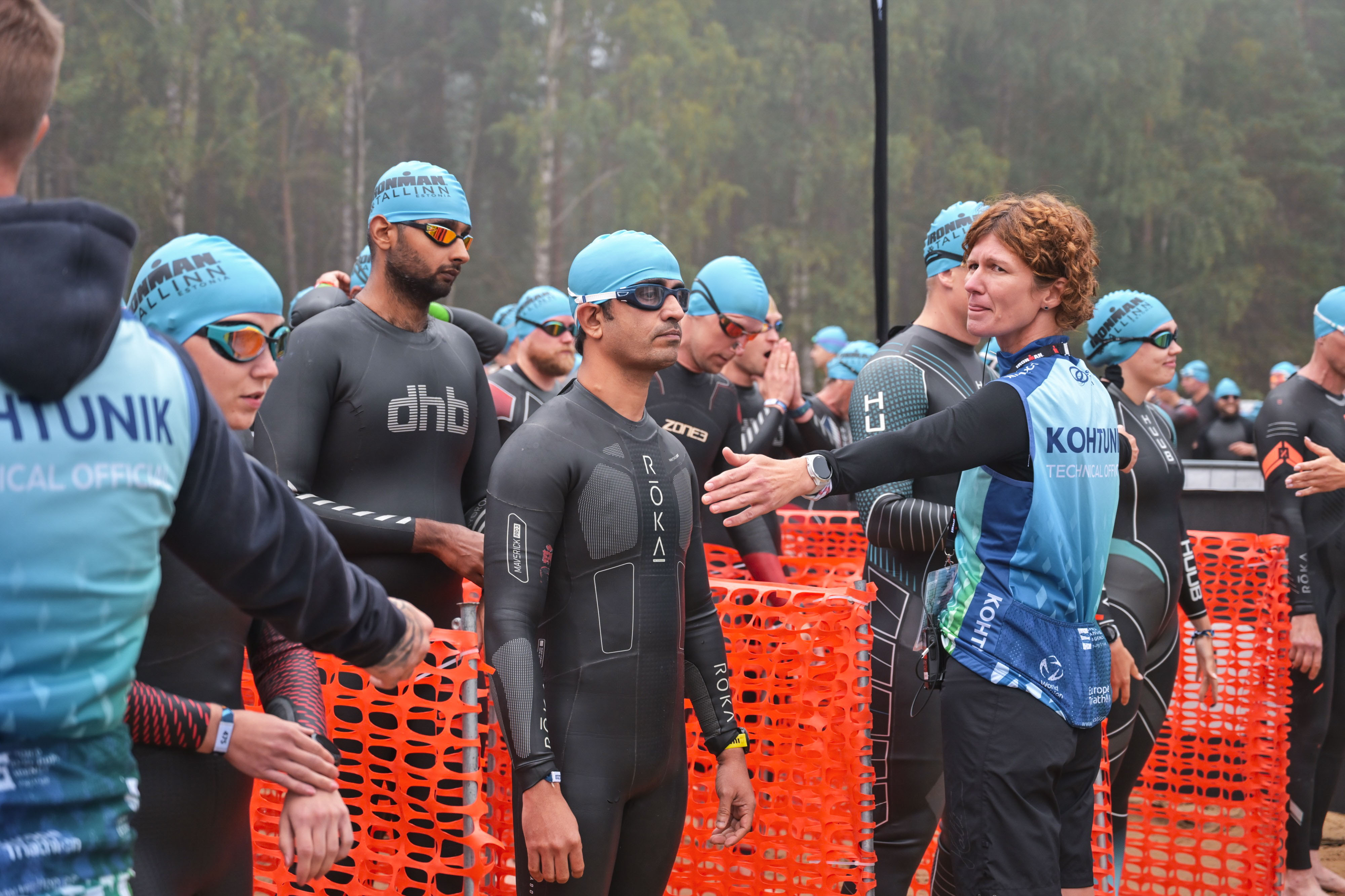 Vivek Sharma at the IRONMAN Tallinn swim start in wetsuit, IRONMAN TALLINN swim caps visible around him