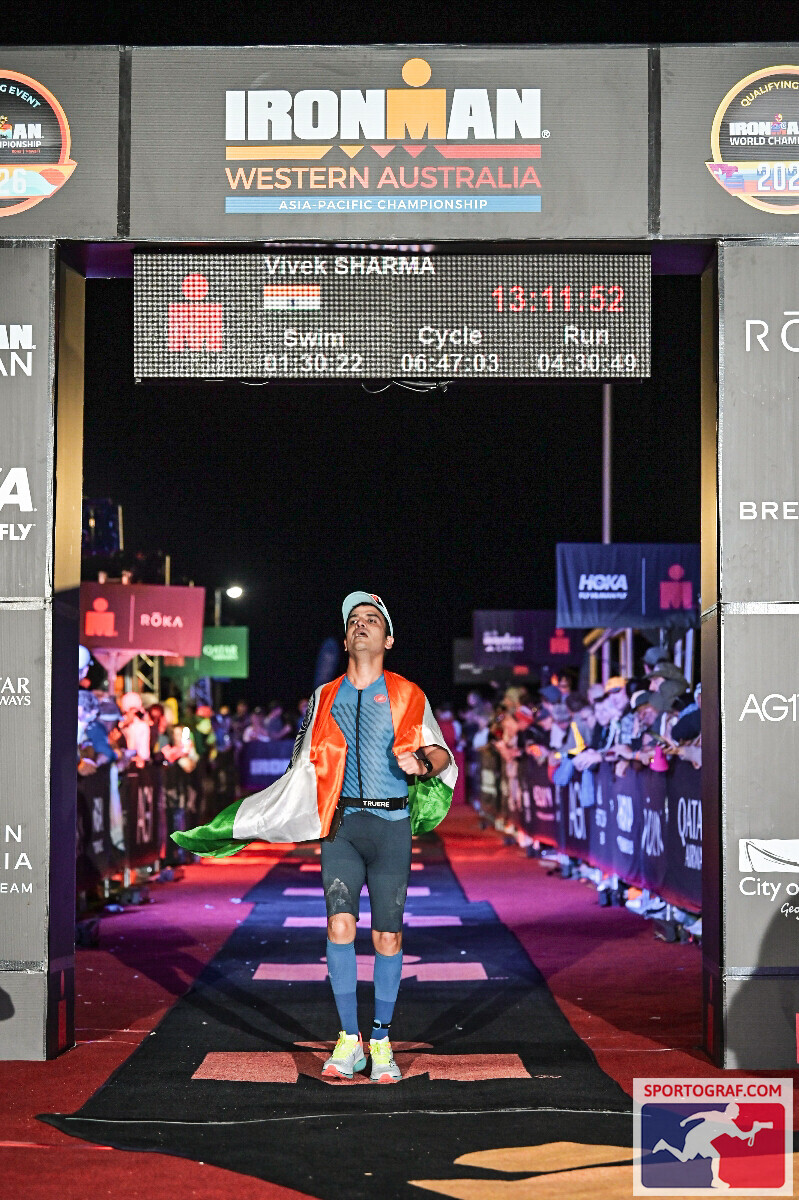 Vivek Sharma at the Ironman Western Australia finish arch, name on the finisher board